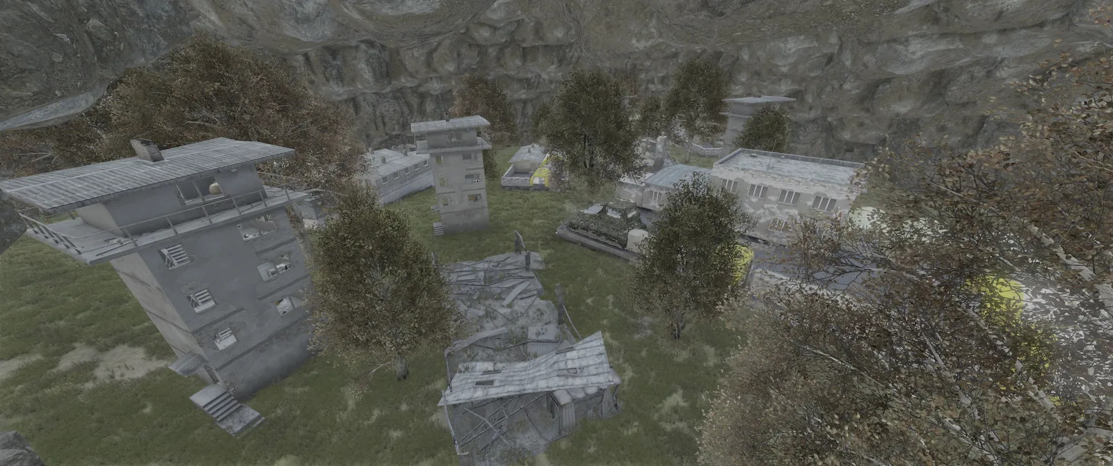 Towers, barracks and a collapsed shed inside a rocky canyon at Lunatics Stronghold, a T6 zone