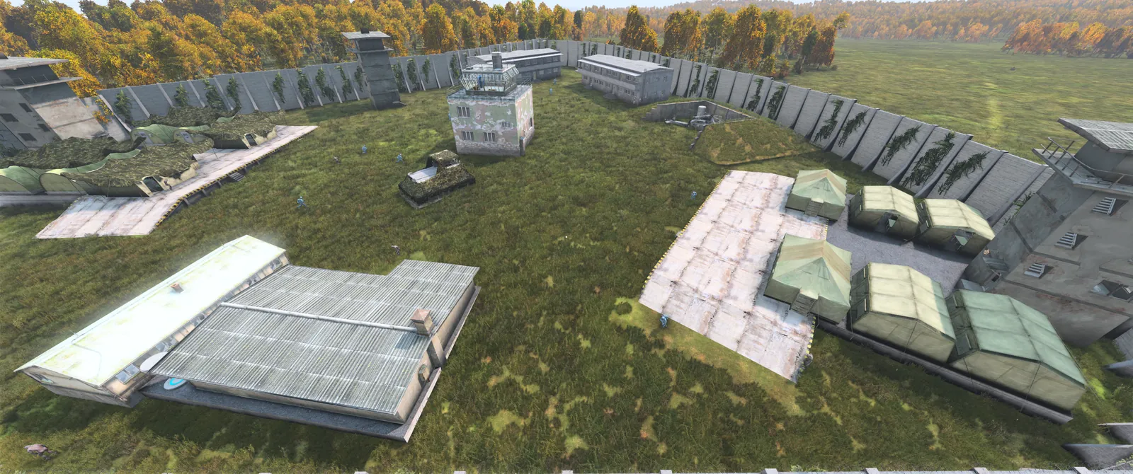 Aerial view of Outcasts Stronghold, a T5 zone with barracks, tents and watchtowers inside tall steel walls